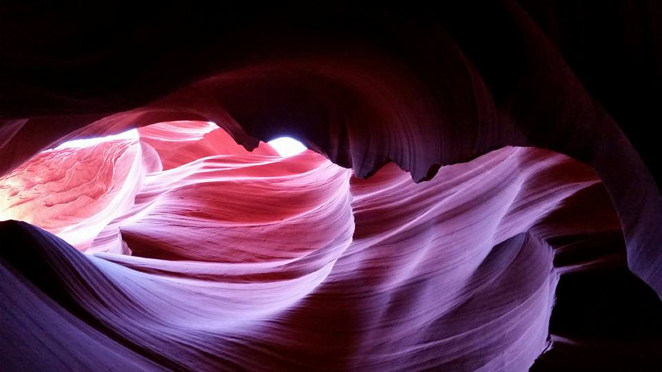 Sunlight falling through the sculpted rose and amber walls of an Arizona slot canyon